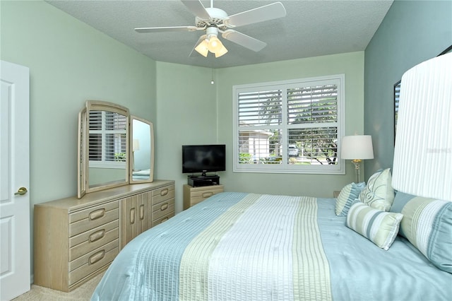 carpeted bedroom with a ceiling fan and a textured ceiling