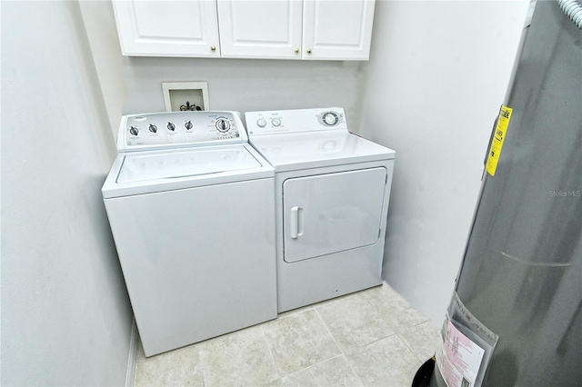 clothes washing area featuring tile patterned flooring, cabinet space, and washer and dryer