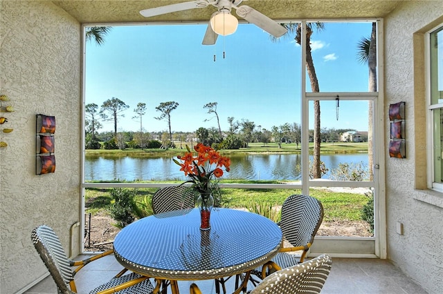 sunroom / solarium with a water view and ceiling fan