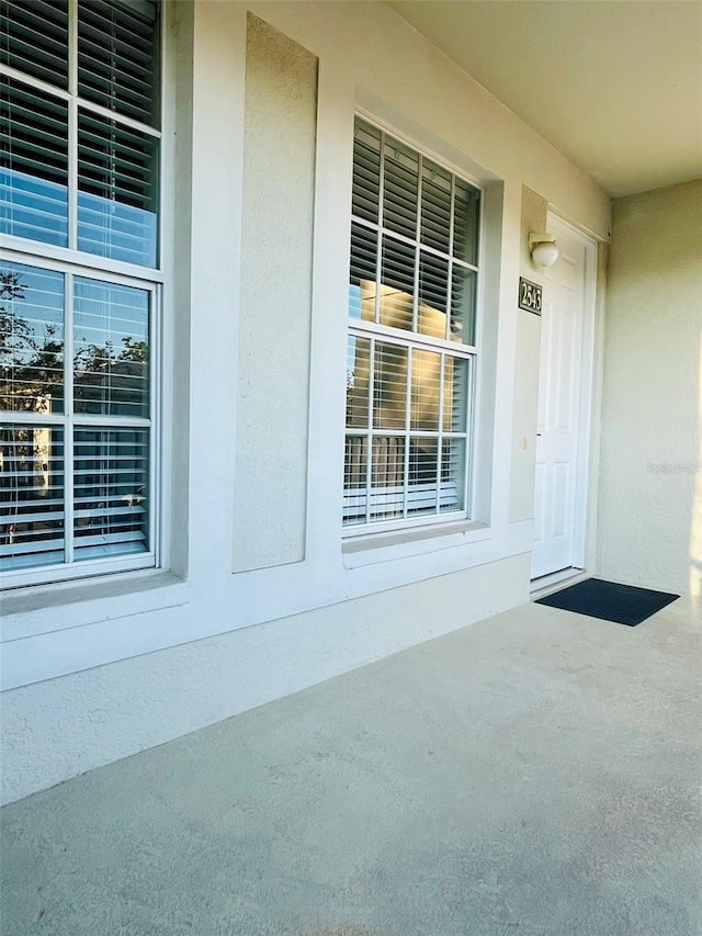 doorway to property featuring stucco siding