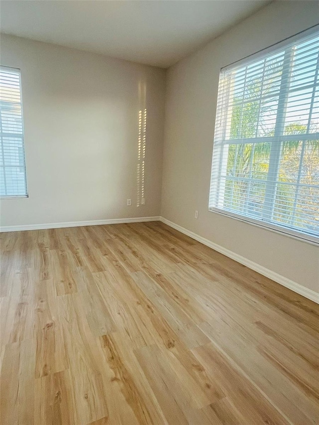 empty room with light wood-style floors and baseboards