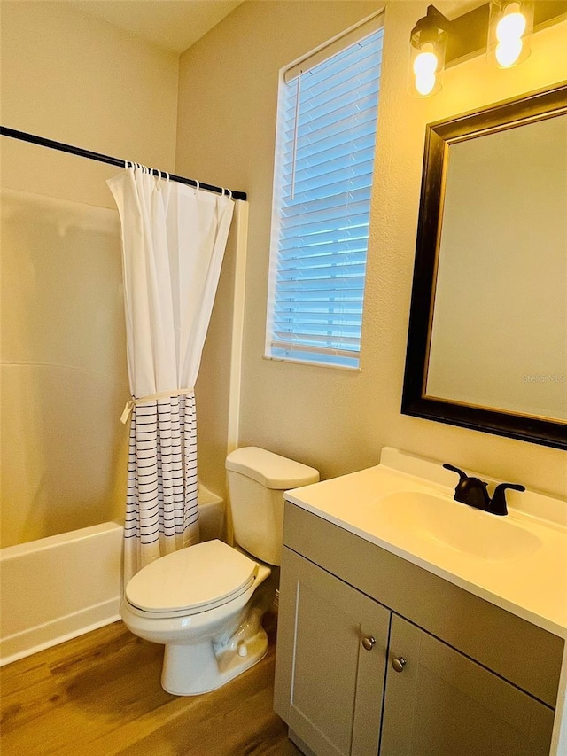 bathroom featuring vanity, shower / tub combo, wood finished floors, and toilet