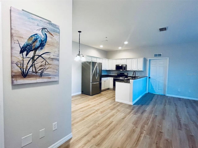 kitchen with visible vents, white cabinets, dark countertops, appliances with stainless steel finishes, and decorative light fixtures