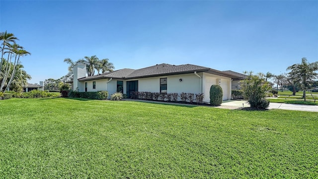 view of side of home featuring a garage, a lawn, concrete driveway, a chimney, and stucco siding