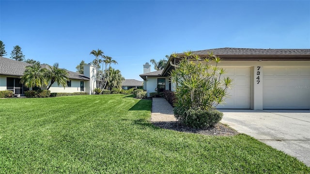 view of front facade with a garage, a front yard, concrete driveway, and stucco siding