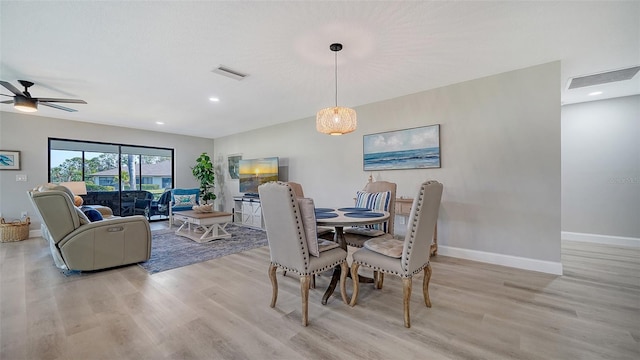 dining space with ceiling fan, light wood finished floors, visible vents, and baseboards