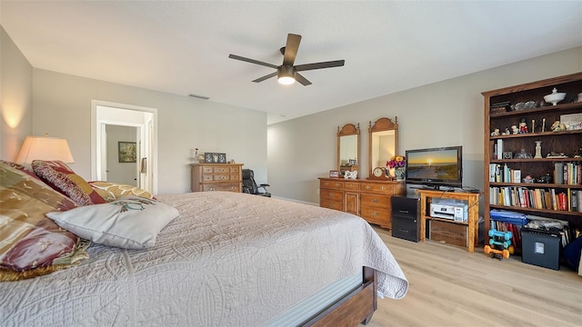 bedroom featuring light wood-type flooring, ceiling fan, and visible vents