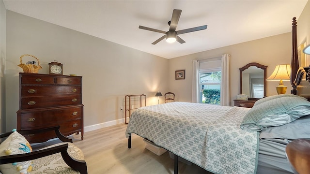 bedroom with light wood finished floors, baseboards, and a ceiling fan