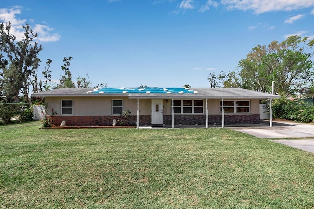 ranch-style home featuring brick siding, a front lawn, and stucco siding