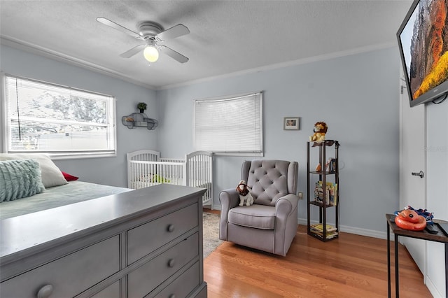 bedroom with ornamental molding, a textured ceiling, and light wood finished floors