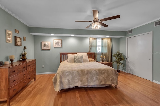 bedroom featuring visible vents, crown molding, light wood-style flooring, and baseboards