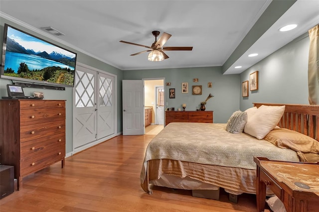 bedroom featuring ensuite bathroom, light wood-style flooring, recessed lighting, visible vents, and crown molding