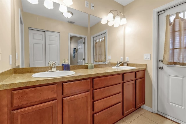 bathroom with double vanity, visible vents, a sink, and tile patterned floors