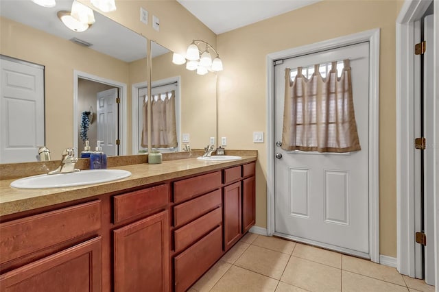 bathroom with double vanity, visible vents, a sink, and tile patterned floors