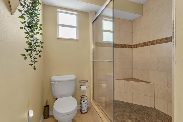 bathroom featuring toilet, a shower stall, baseboards, and tile patterned floors