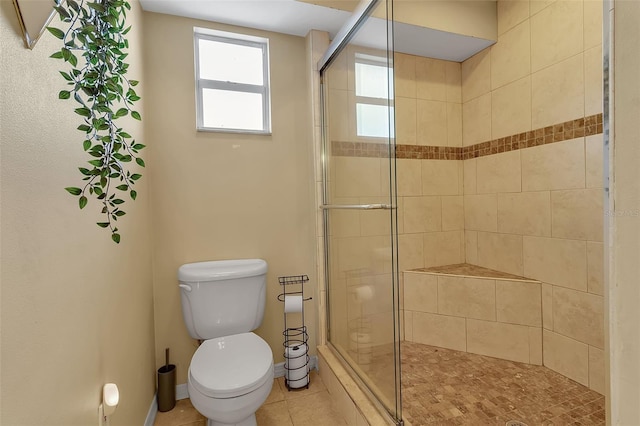 bathroom with toilet, a stall shower, tile patterned flooring, and baseboards