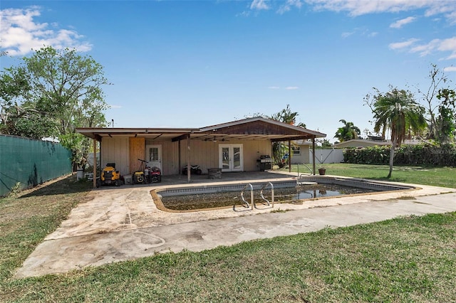 rear view of property featuring a patio, french doors, a lawn, and a fenced backyard