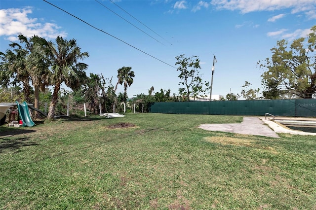 view of yard featuring fence and playground community