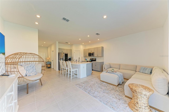 living room featuring light tile patterned flooring, visible vents, and recessed lighting