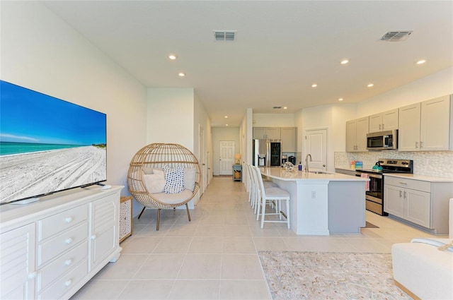 kitchen featuring visible vents, appliances with stainless steel finishes, a sink, and gray cabinetry