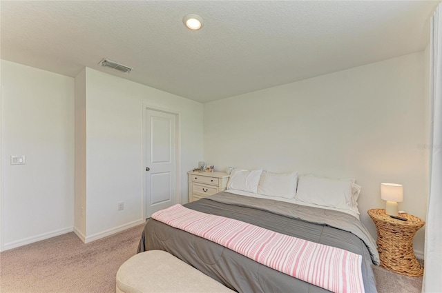 bedroom featuring light carpet, visible vents, baseboards, and a textured ceiling