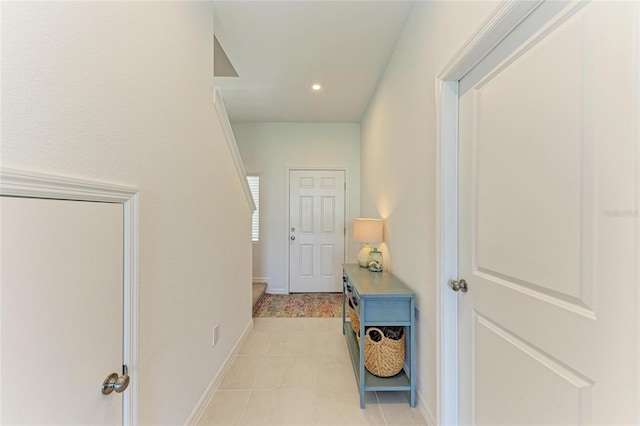 hallway with light tile patterned flooring and baseboards