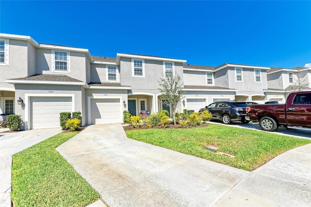 townhome / multi-family property with driveway, a residential view, an attached garage, a front lawn, and stucco siding