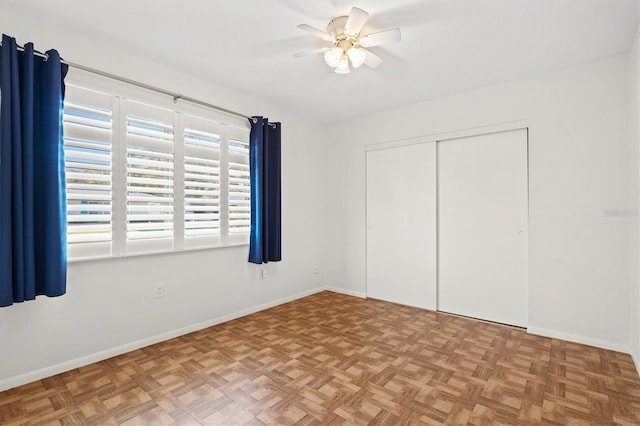 unfurnished bedroom with ceiling fan, baseboards, and a closet