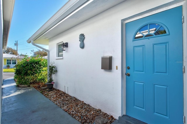 view of exterior entry with stucco siding