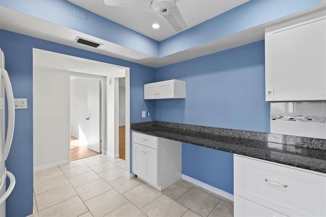 kitchen with visible vents, backsplash, built in study area, ceiling fan, and white cabinetry