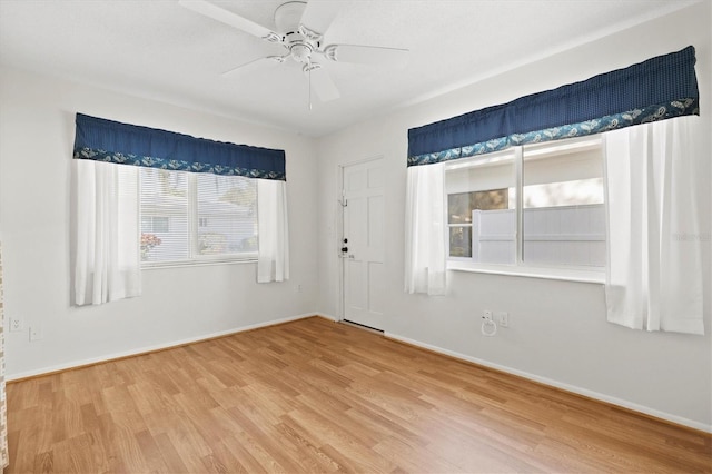 spare room featuring ceiling fan, baseboards, and wood finished floors