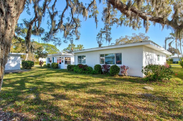 single story home with a front lawn and stucco siding