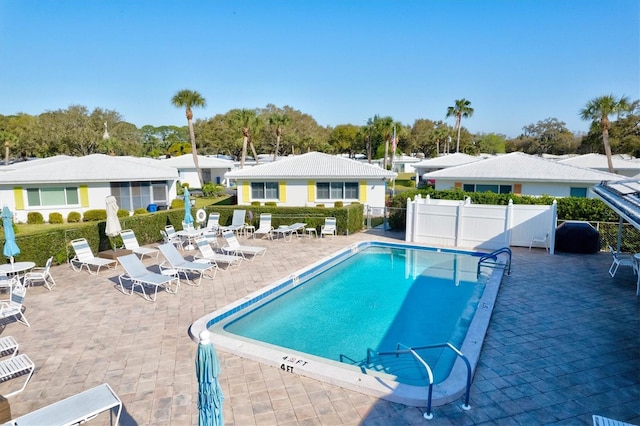 pool featuring fence and a patio