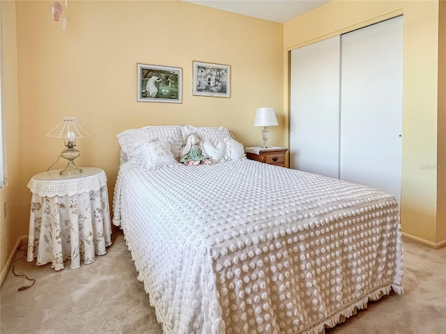 carpeted bedroom featuring a closet and baseboards