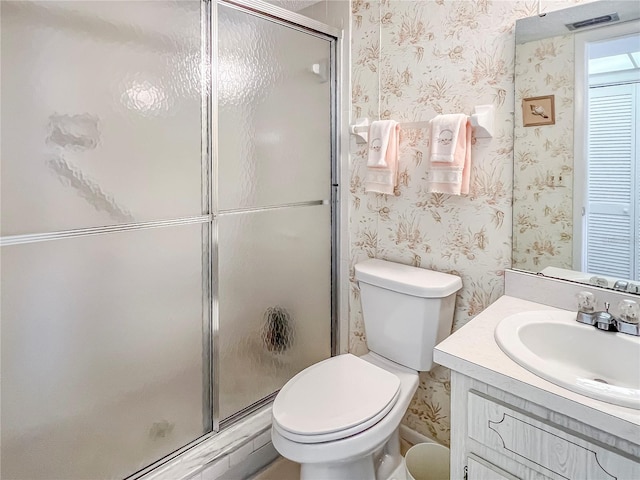 full bath featuring a stall shower, toilet, and wallpapered walls