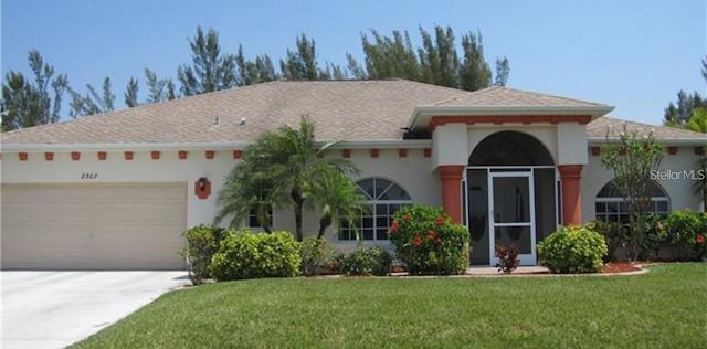 view of front of house with a garage, a front lawn, concrete driveway, and stucco siding