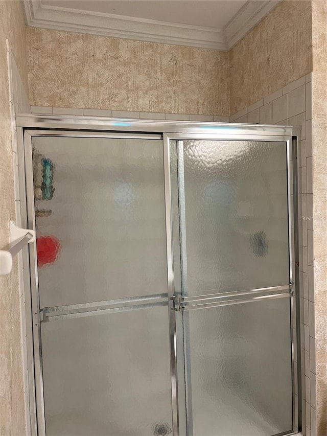 bathroom featuring ornamental molding and a shower stall