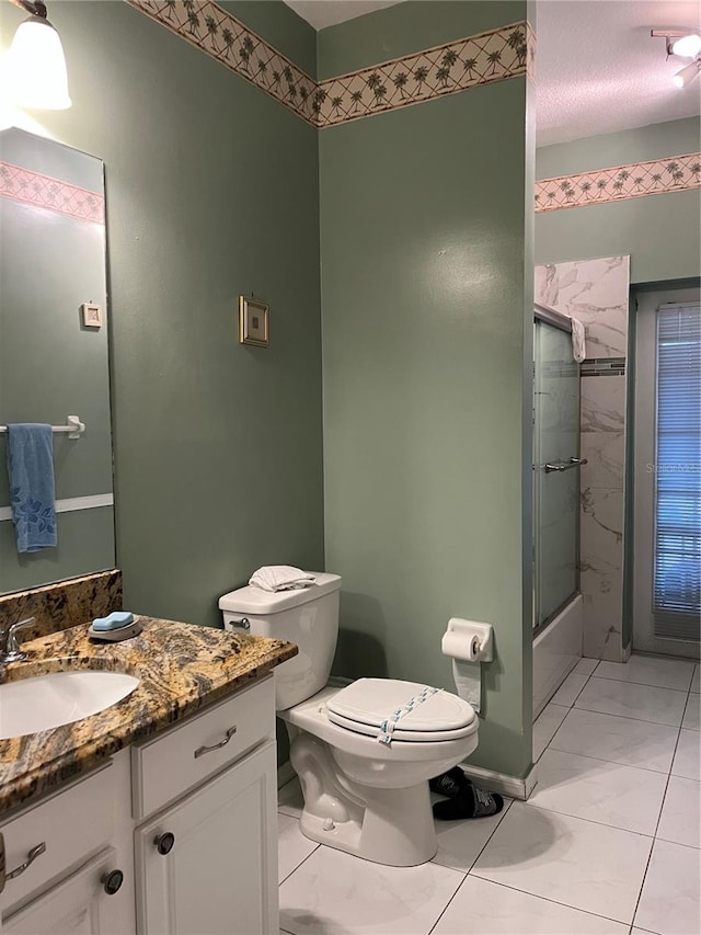 bathroom with shower / bath combination with glass door, vanity, and toilet