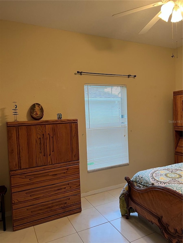 bedroom with light tile patterned floors, ceiling fan, and baseboards