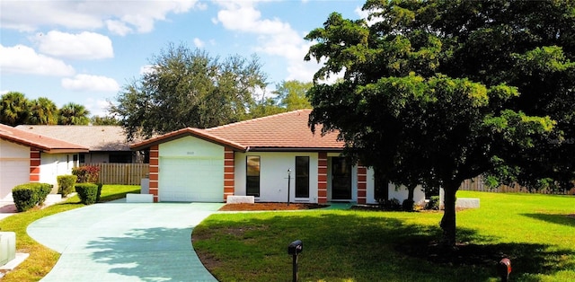 view of front of home featuring a garage, fence, concrete driveway, stucco siding, and a front yard