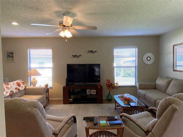 living area featuring a textured ceiling, plenty of natural light, and a ceiling fan