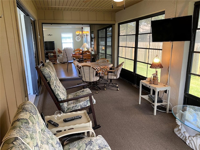 sunroom featuring a chandelier and wooden ceiling