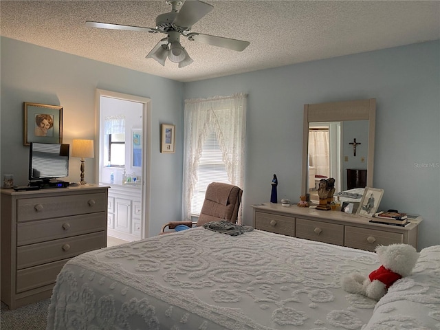 bedroom featuring ceiling fan, a textured ceiling, and ensuite bath