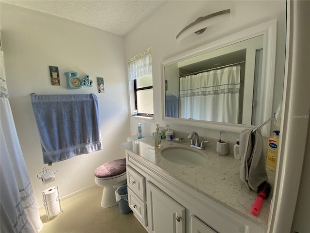 bathroom with a textured ceiling, vanity, and toilet