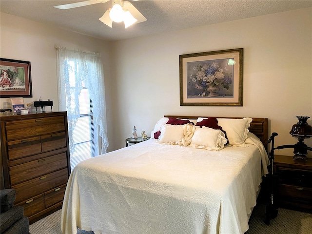 bedroom with carpet floors, a ceiling fan, and a textured ceiling