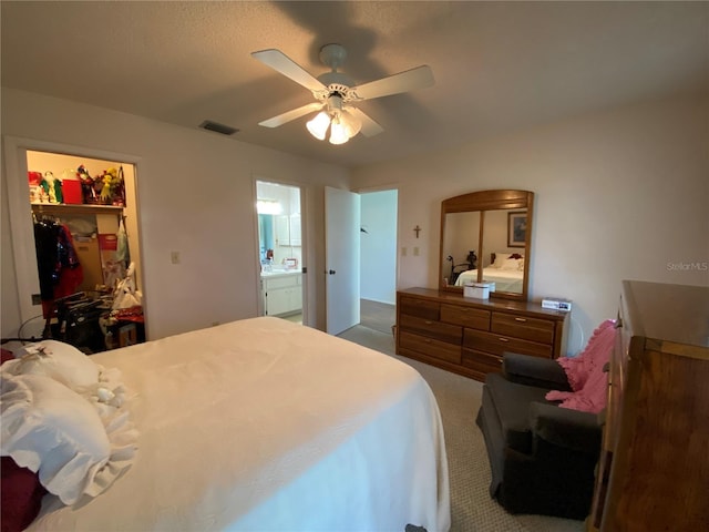 bedroom with carpet, a closet, visible vents, a spacious closet, and a ceiling fan