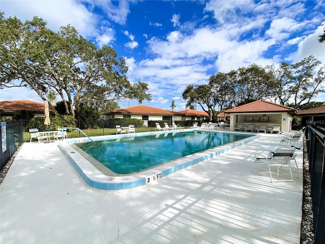 pool with a patio and fence