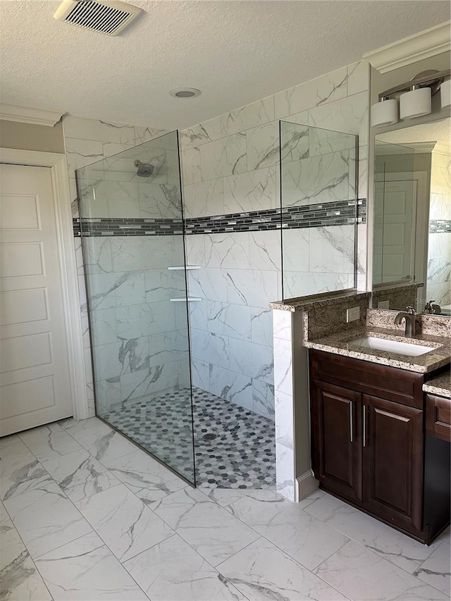 full bathroom with marble finish floor, visible vents, a walk in shower, and a textured ceiling