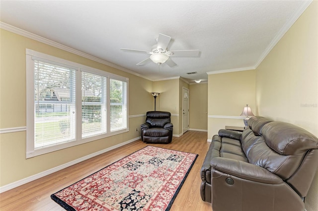 living area with ornamental molding, wood finished floors, and baseboards