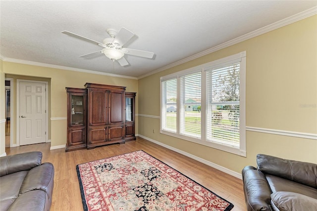 living room with ornamental molding, baseboards, and light wood finished floors